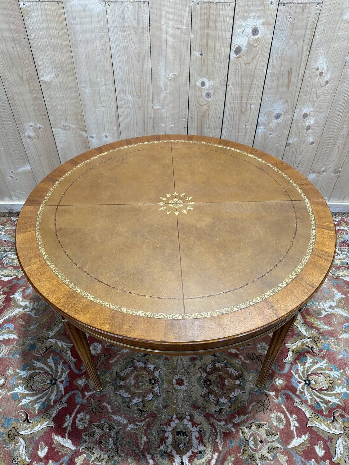 Round dining table with leather top in Louis XVI style.