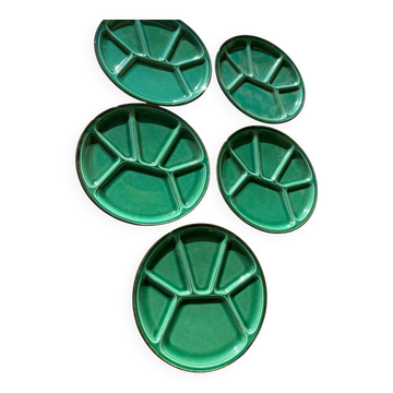 Many glazed stoneware plates with compartments.