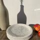4 black speckled dessert plates on a vintage white background