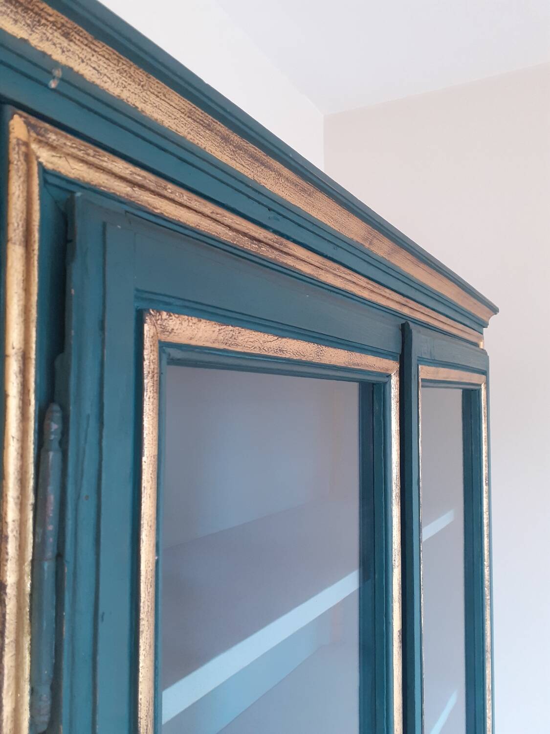 Glass-fronted cabinet in weathered green wood