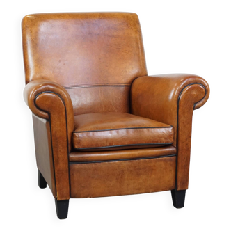 Fauteuil vintage en cuir de mouton couleur cognac avec finition passepoilée