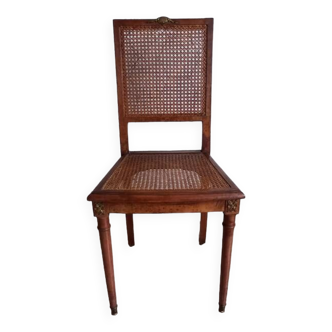 Art deco cane chair with bronze ornaments.