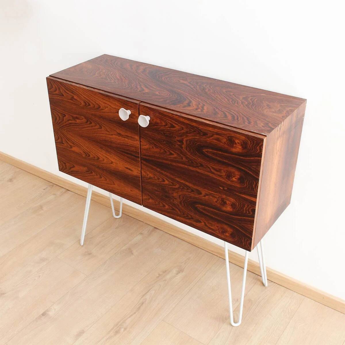 Buffet en palissandre avec des pieds en métal gris clair en forme de épingle.