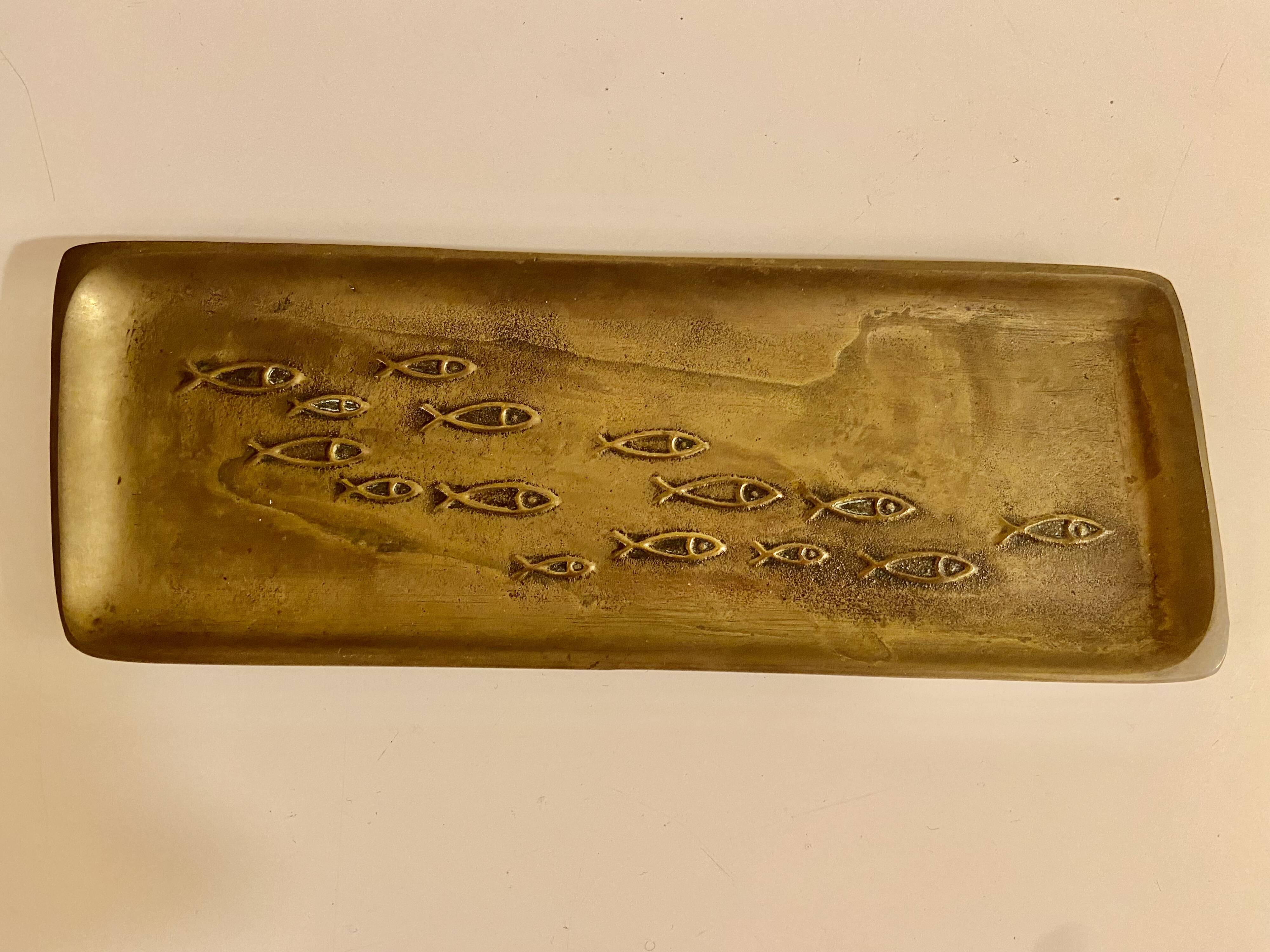 Bronze pocket emptier with fish decoration.