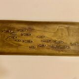 Bronze pocket emptier with fish decoration.