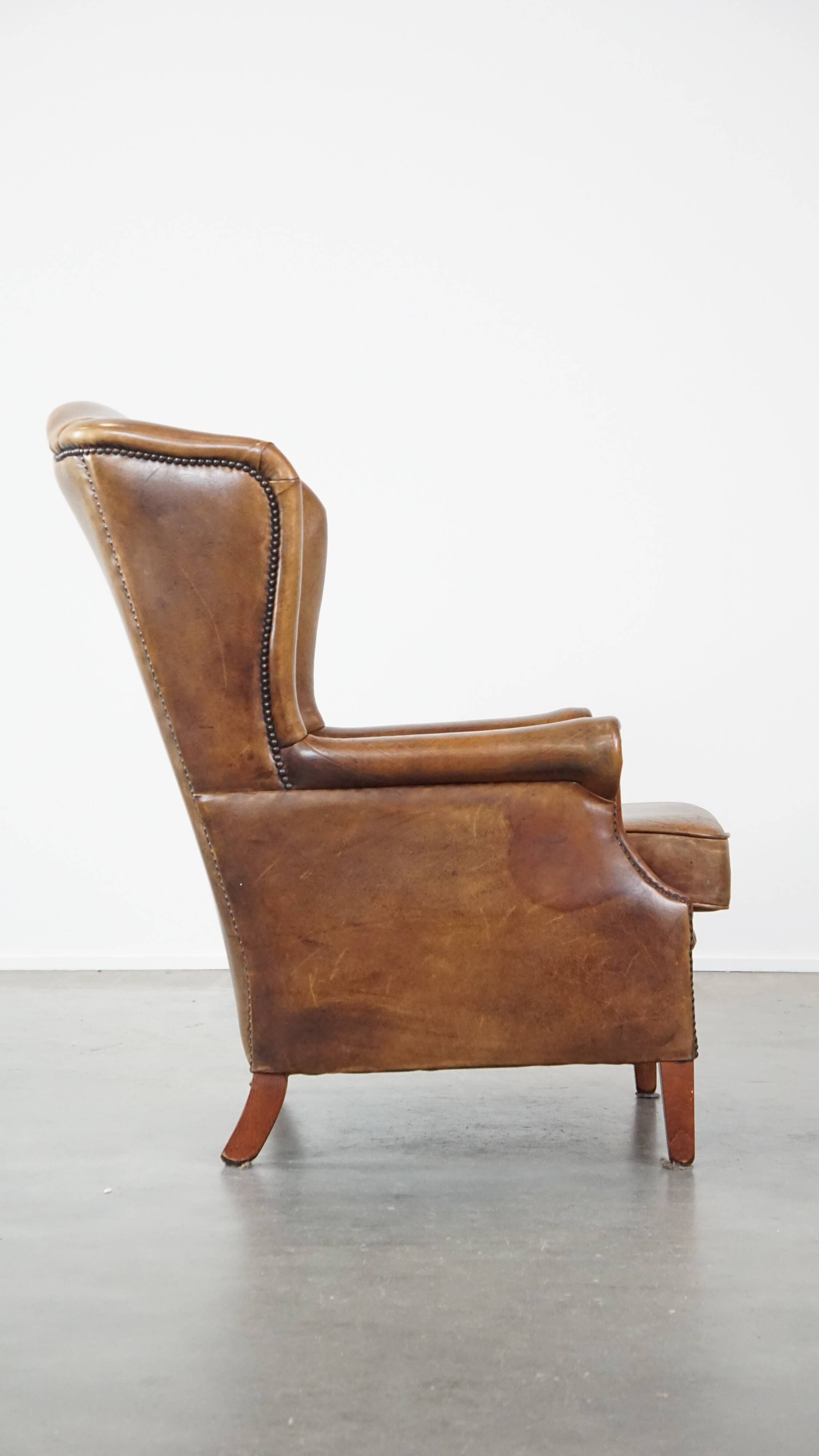 Charming sheep leather wingback armchair with a beautiful patina and excellent seating comfort