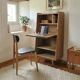 Vintage 1960s secretary desk with an angled design, light wood, and tapered legs.