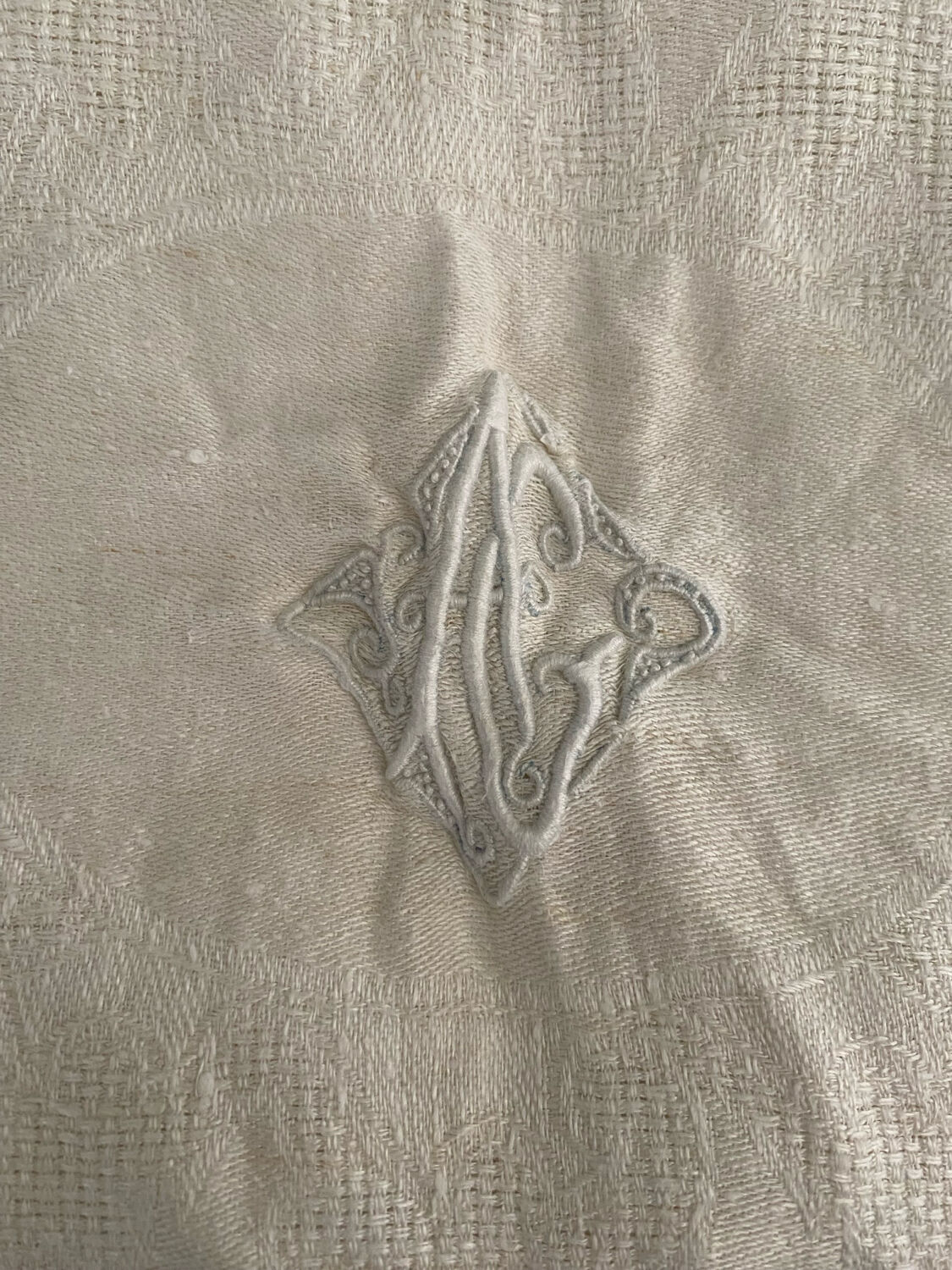 Floral damask cotton tablecloth with central monogram AC.