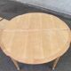 Extendable round table in renovated Louis XVI style, made of light wood, with 2 extensions.