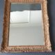 Large Montparnasse rocaille style frame in carved wood mounted in mirror.