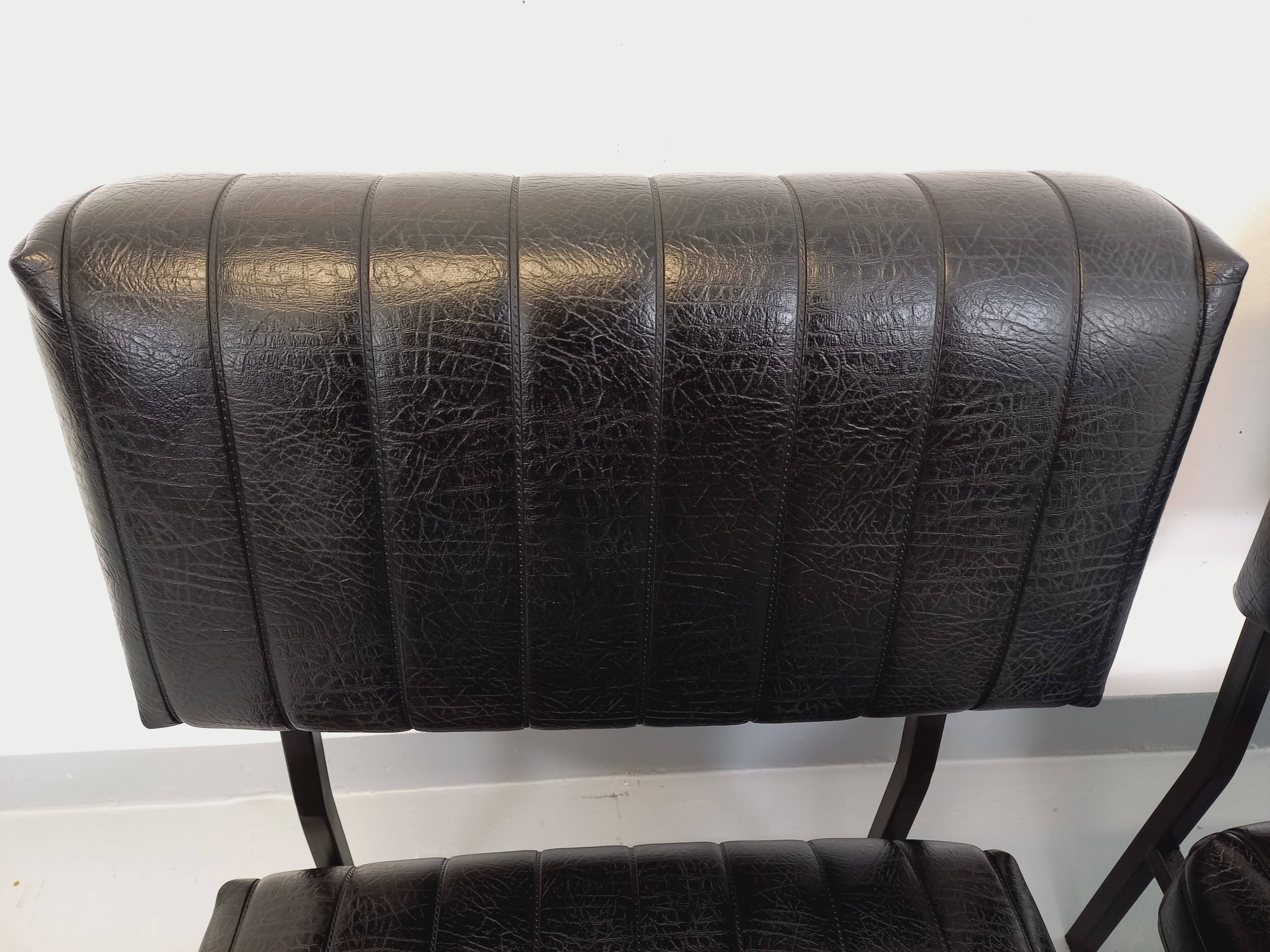 Set of 2 vintage modernist armchairs in black faux leather and metal.