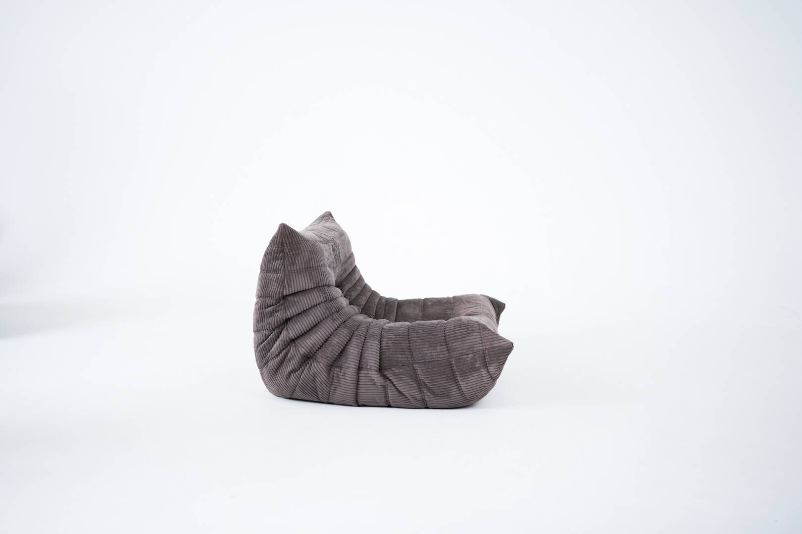Ensemble de chaise et pouf Togo en velours côtelé marron.