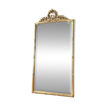 Antique mirror with a gilded pediment in the Louis XVI style.