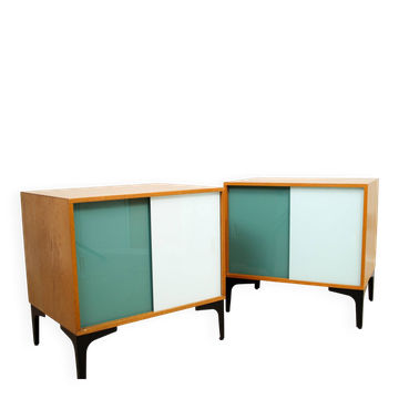 A pair of vintage mid-century bedside tables with glass sliding doors