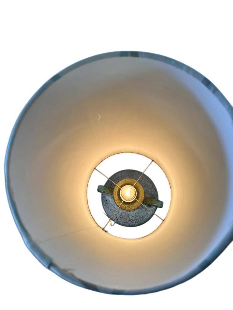 Vintage ceramic floor lamp with illuminated base.