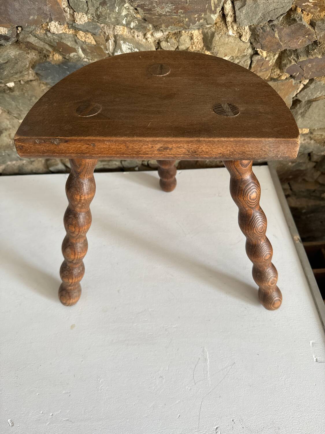 Low tripod stool with turned legs