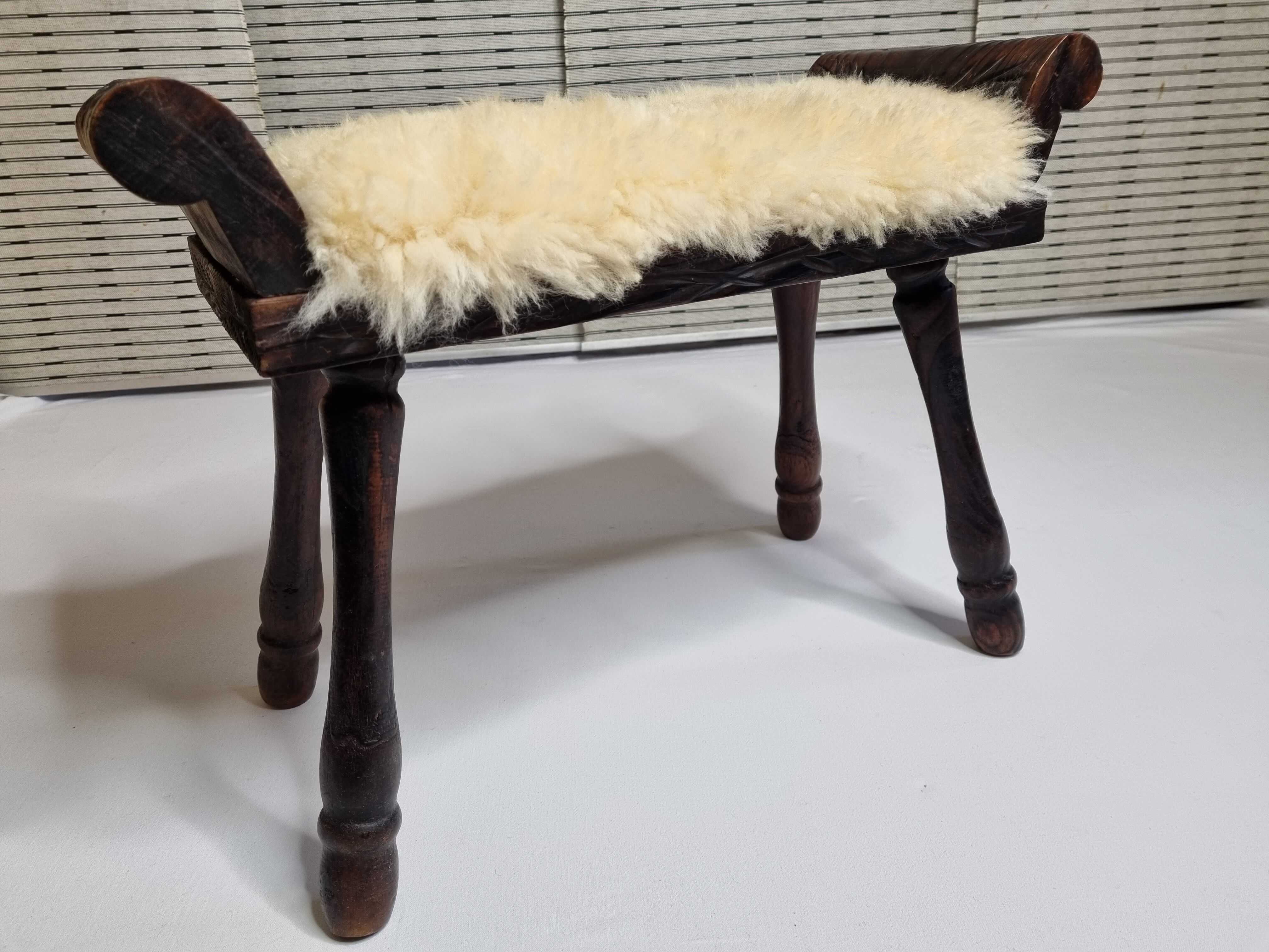Carved wooden stool covered with Celtic-style sheepskin