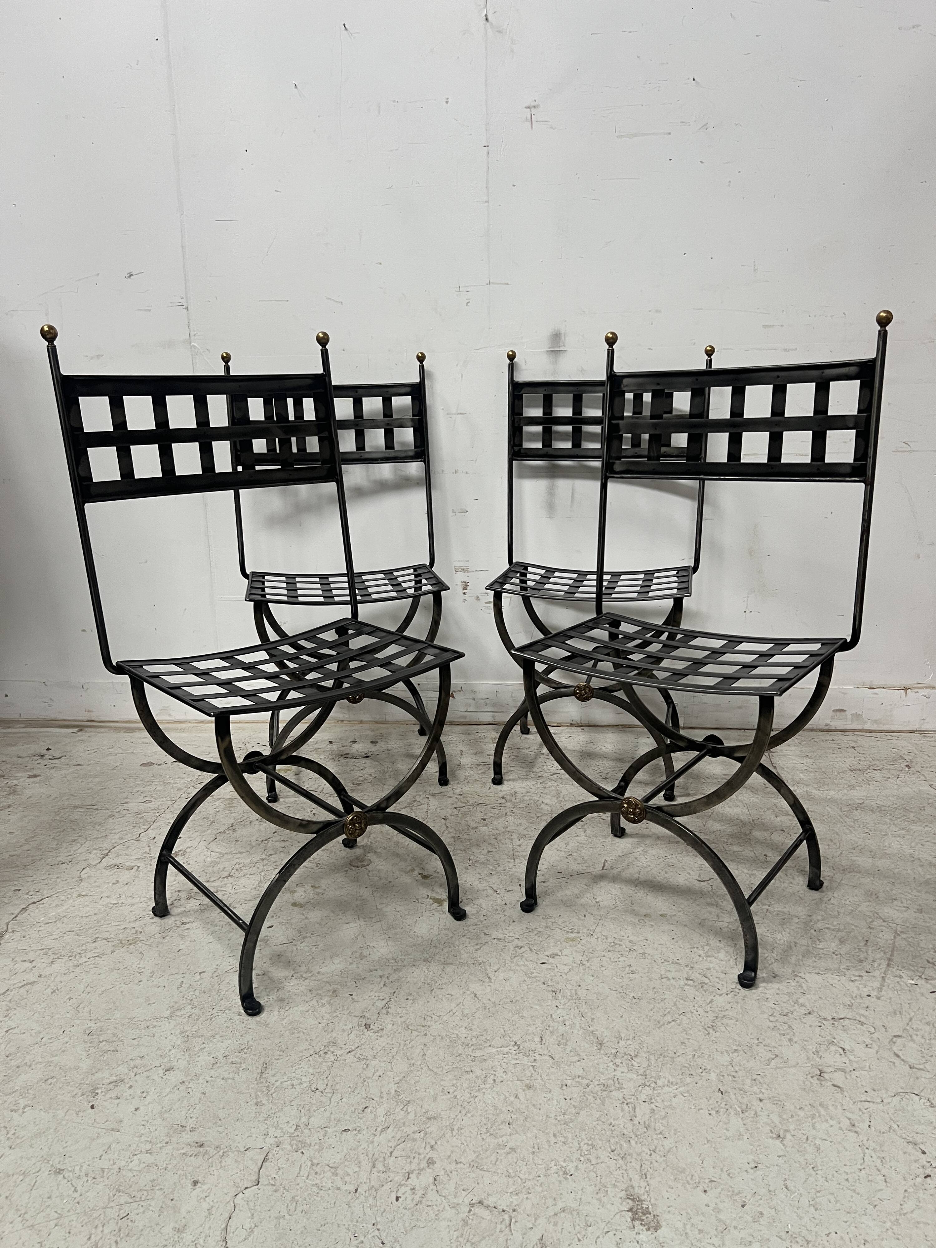 Set of four wrought iron chairs, with a reclining X-shaped base, seat and backrest.