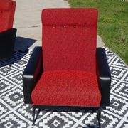 Pair of vintage armchairs in black faux leather and red fabric.