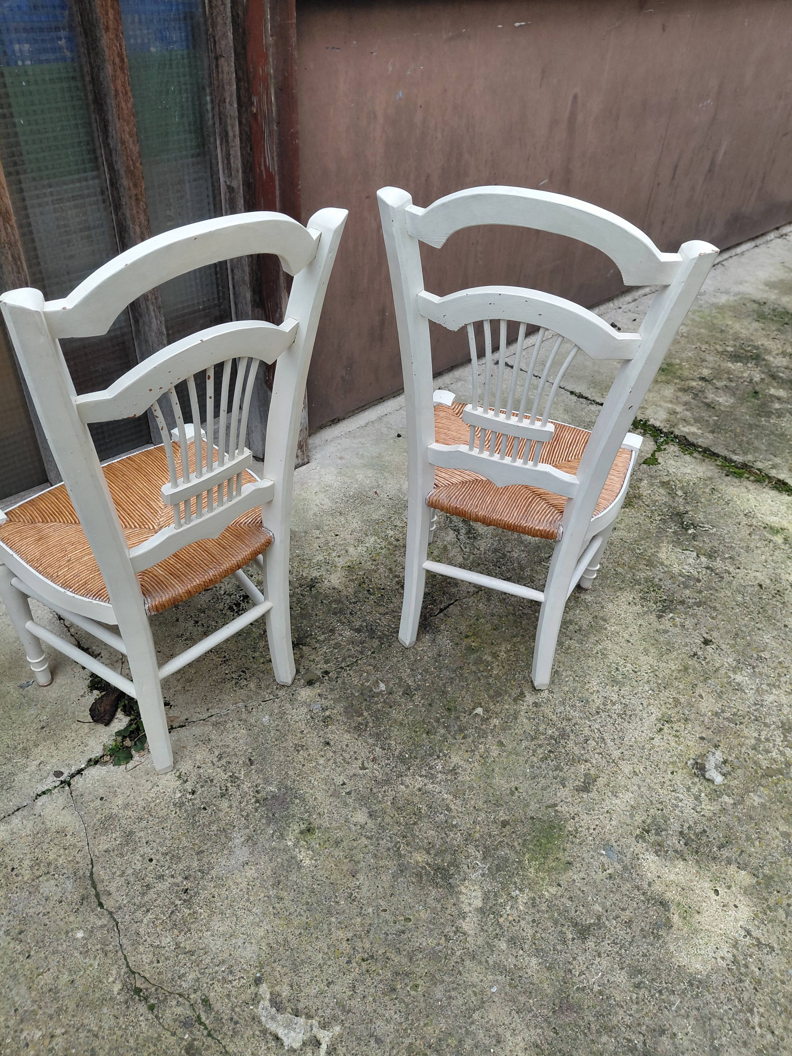 Pair of straw-seated chairs with white-stained wood.