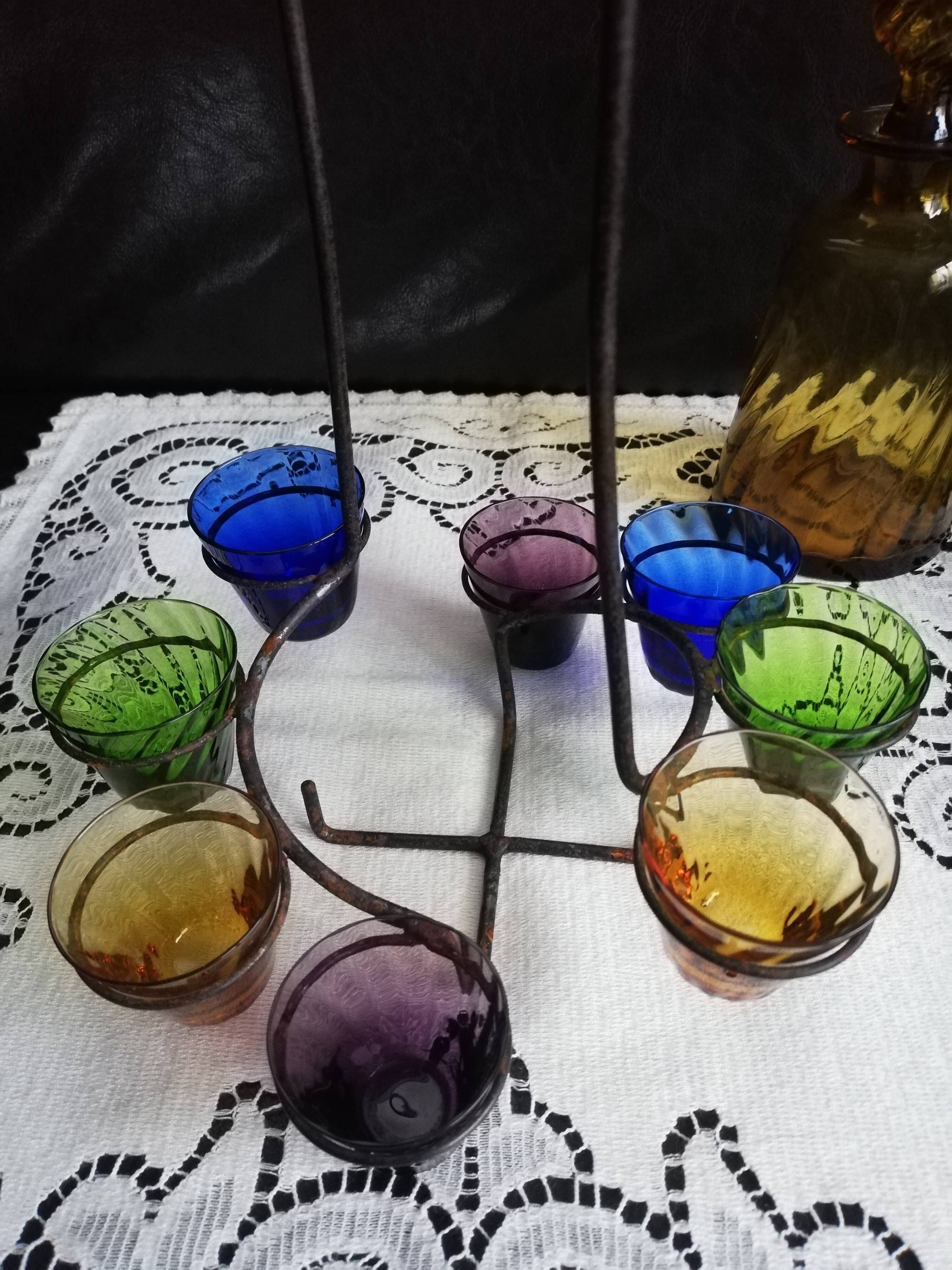 Old Italian alcohol decanter and its colorful glasses