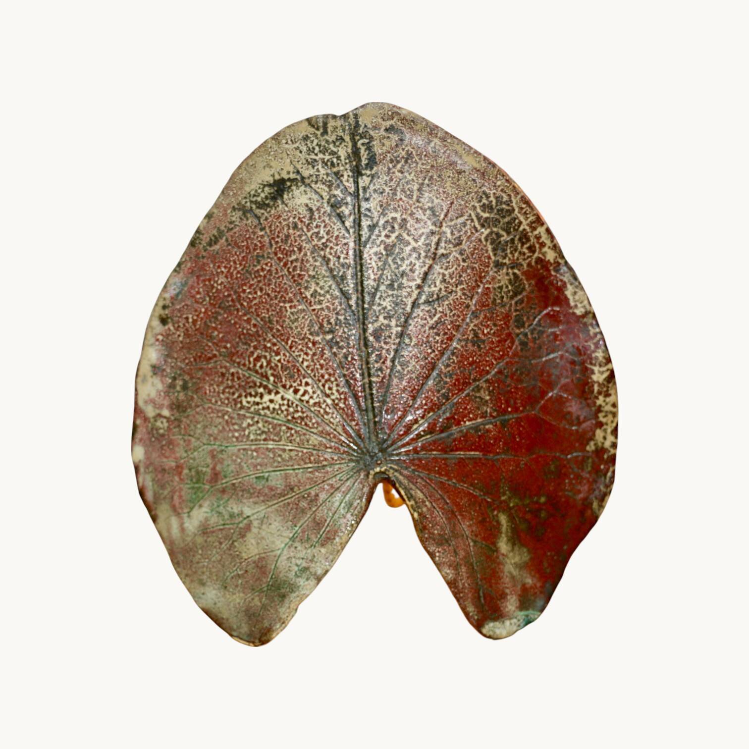 A ceramic lamp in the shape of a leaf.
