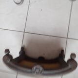 Antique carved stool in an arched shape covered in handmade tapestry