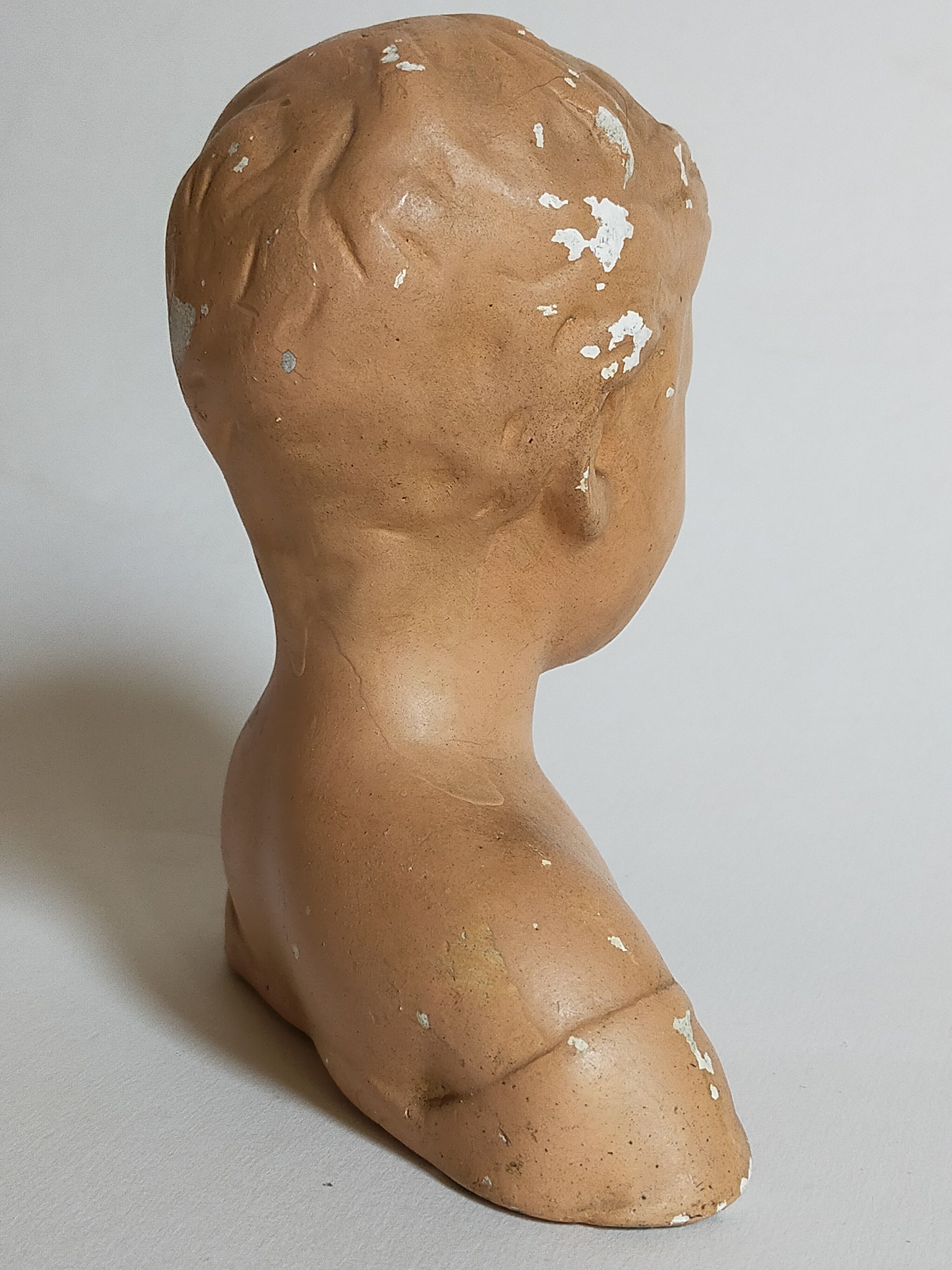 Bust of a small child in ancient plaster