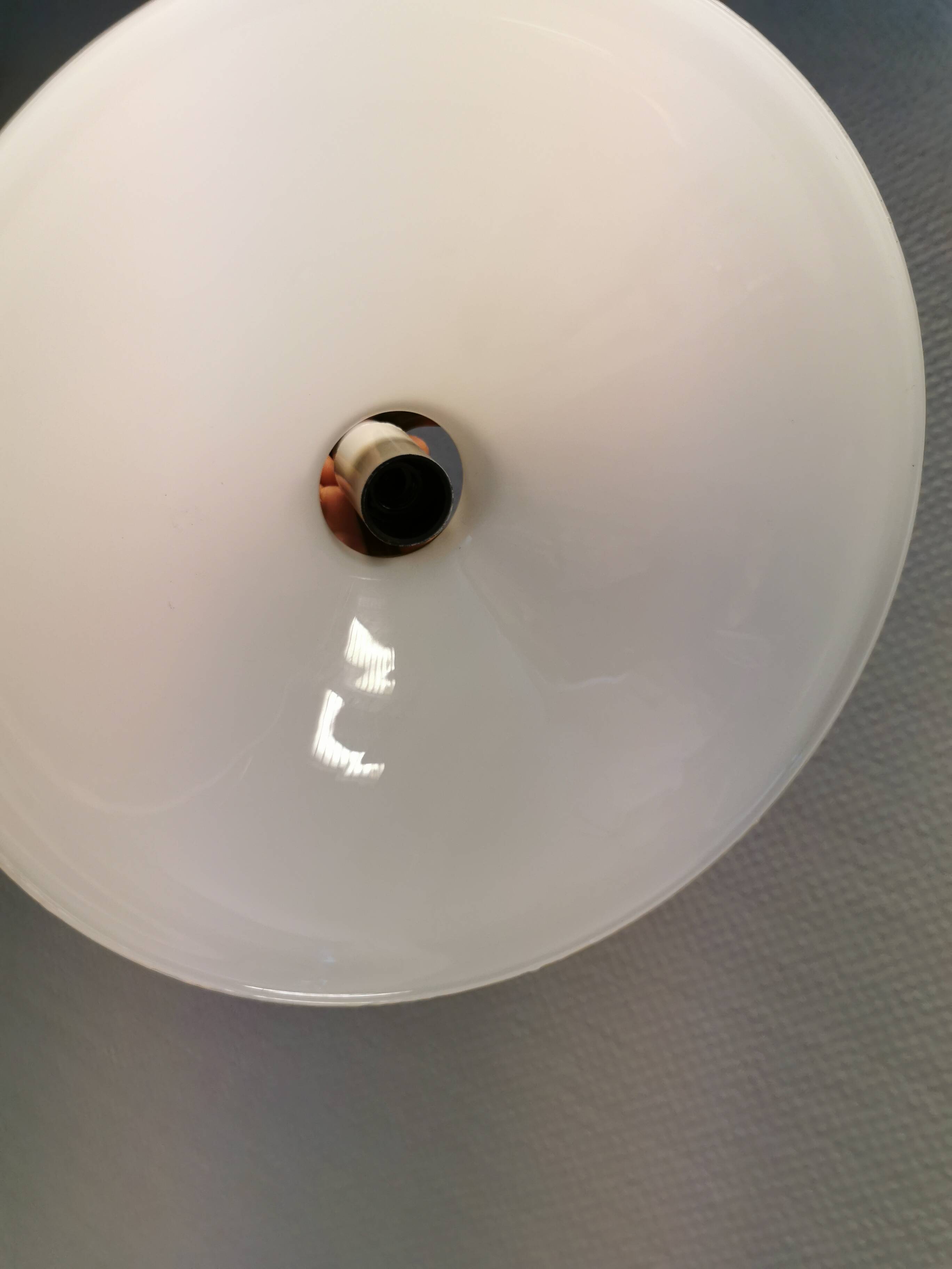 A set of hanging lamps in milky white opal glass with brass top.