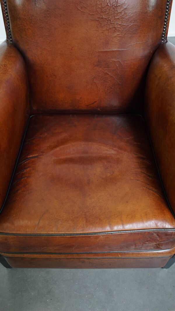 Fauteuil en cuir de mouton couleur cognac avec passepoil noir