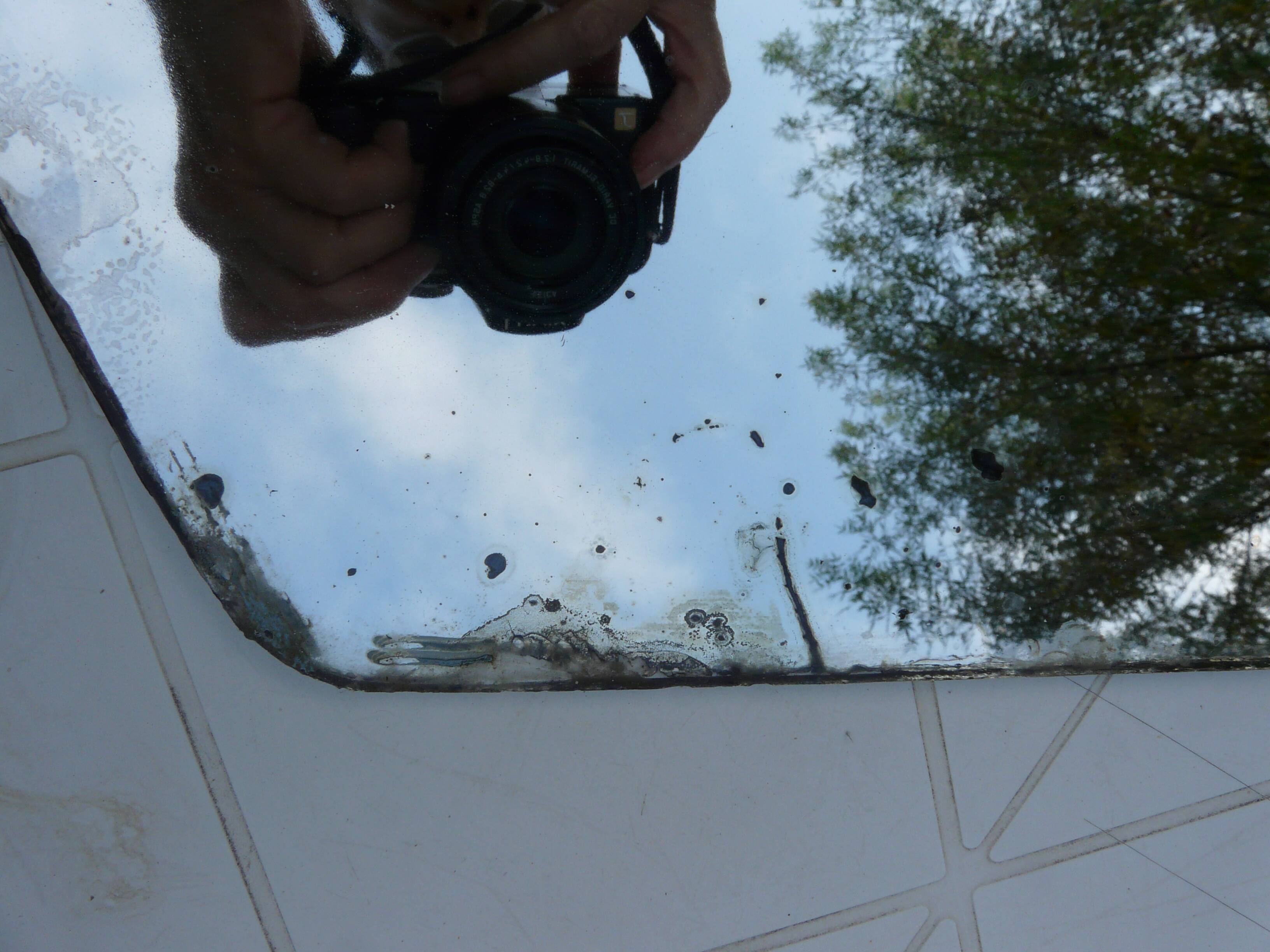 Beveled mirror with art-deco wrought iron frame and floral decor with hanging chain