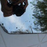 Beveled mirror with art-deco wrought iron frame and floral decor with hanging chain