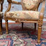 Paire de fauteuils médaillon en bois naturel de style Louis XVI