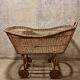 Vintage wicker cradle on wheels