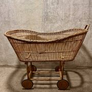 Vintage wicker cradle on wheels