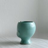 Turquoise plant pot in the shape of a vintage doll's head.