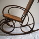 Rocking-chair en bois teinté et assise cannée