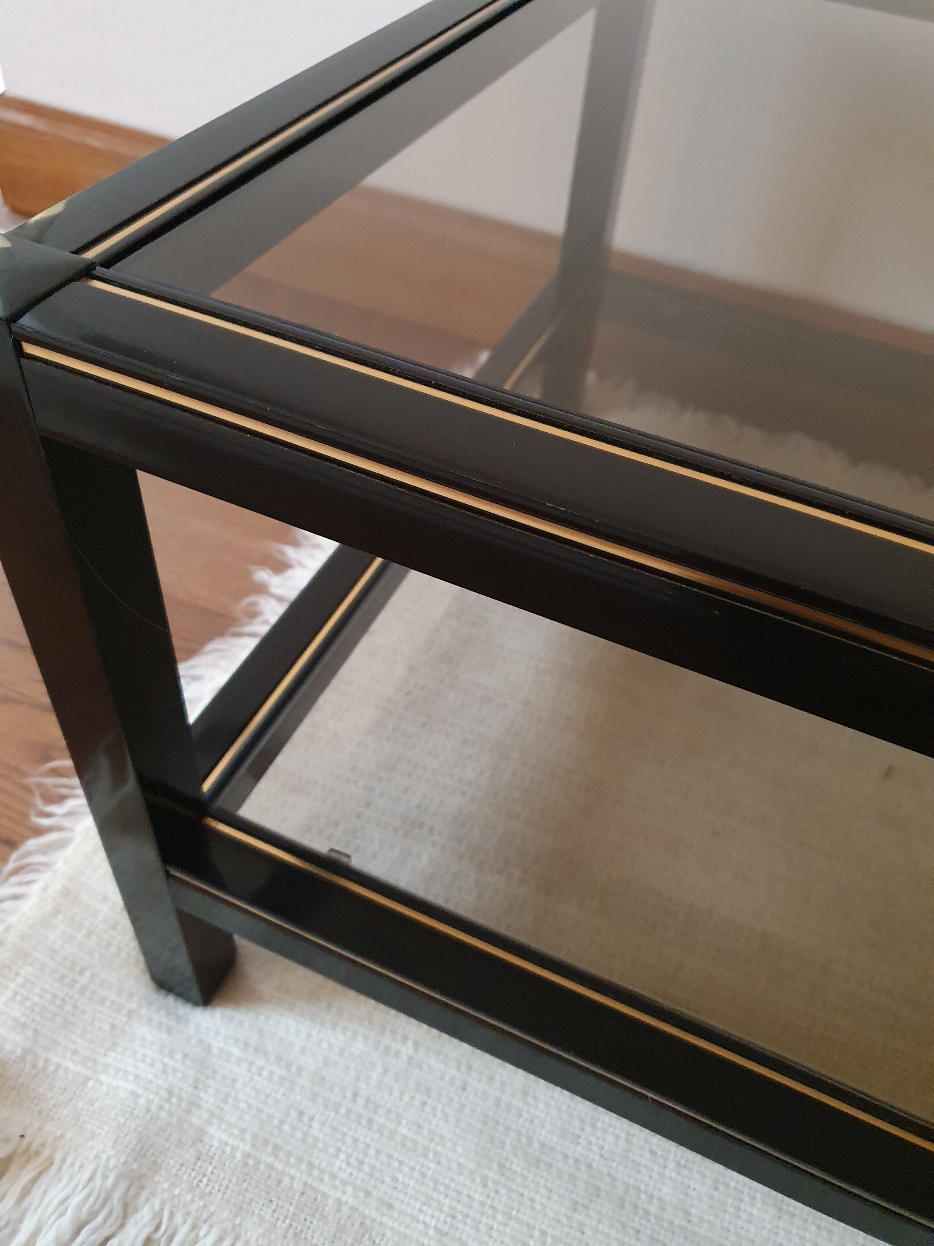 Black and gold coffee table with a double smoked glass top