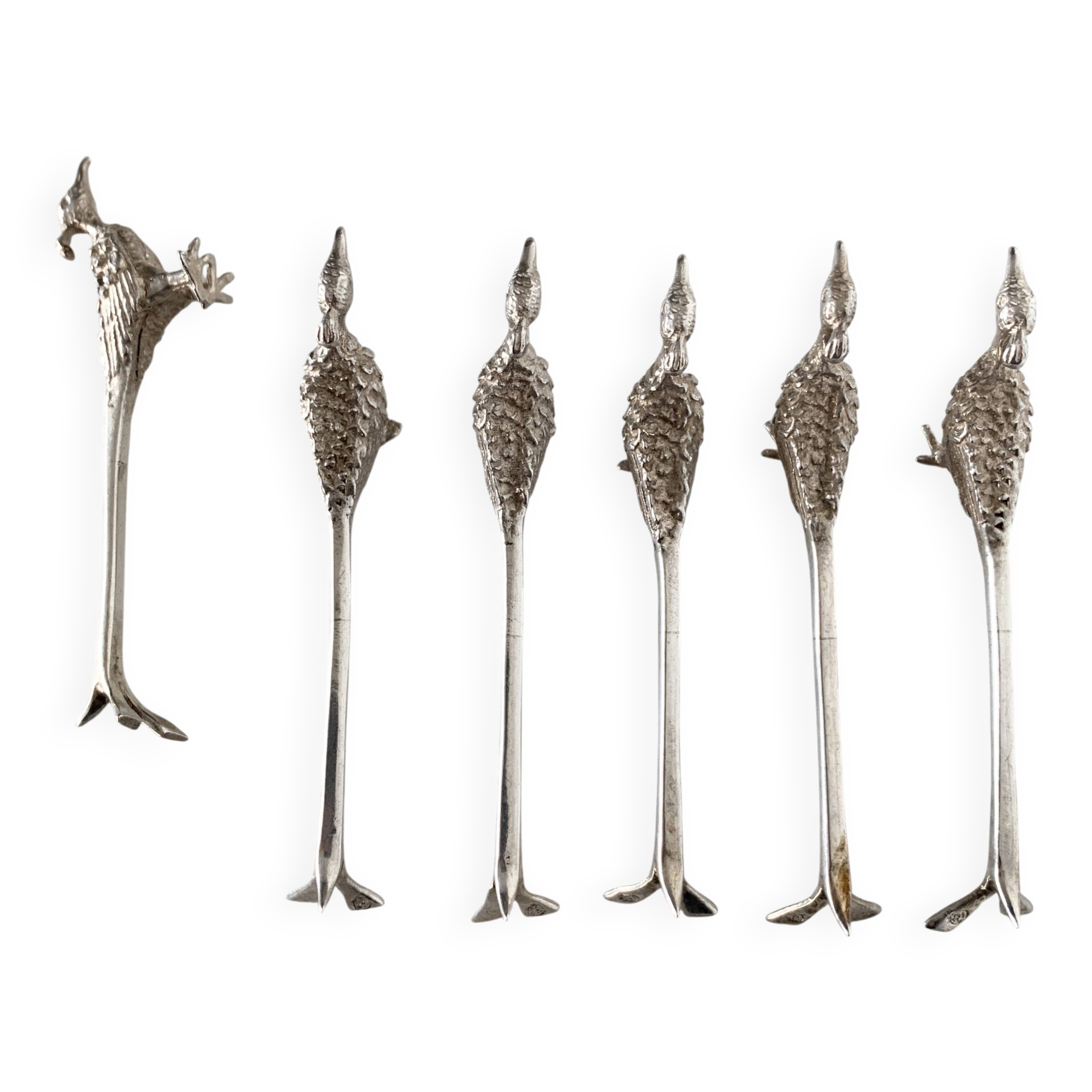 Six silver-plated knife rests in the shape of peacocks.