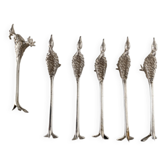 Six silver-plated knife rests in the shape of peacocks.