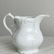Old white porcelain milk jug, cream jug with relief.