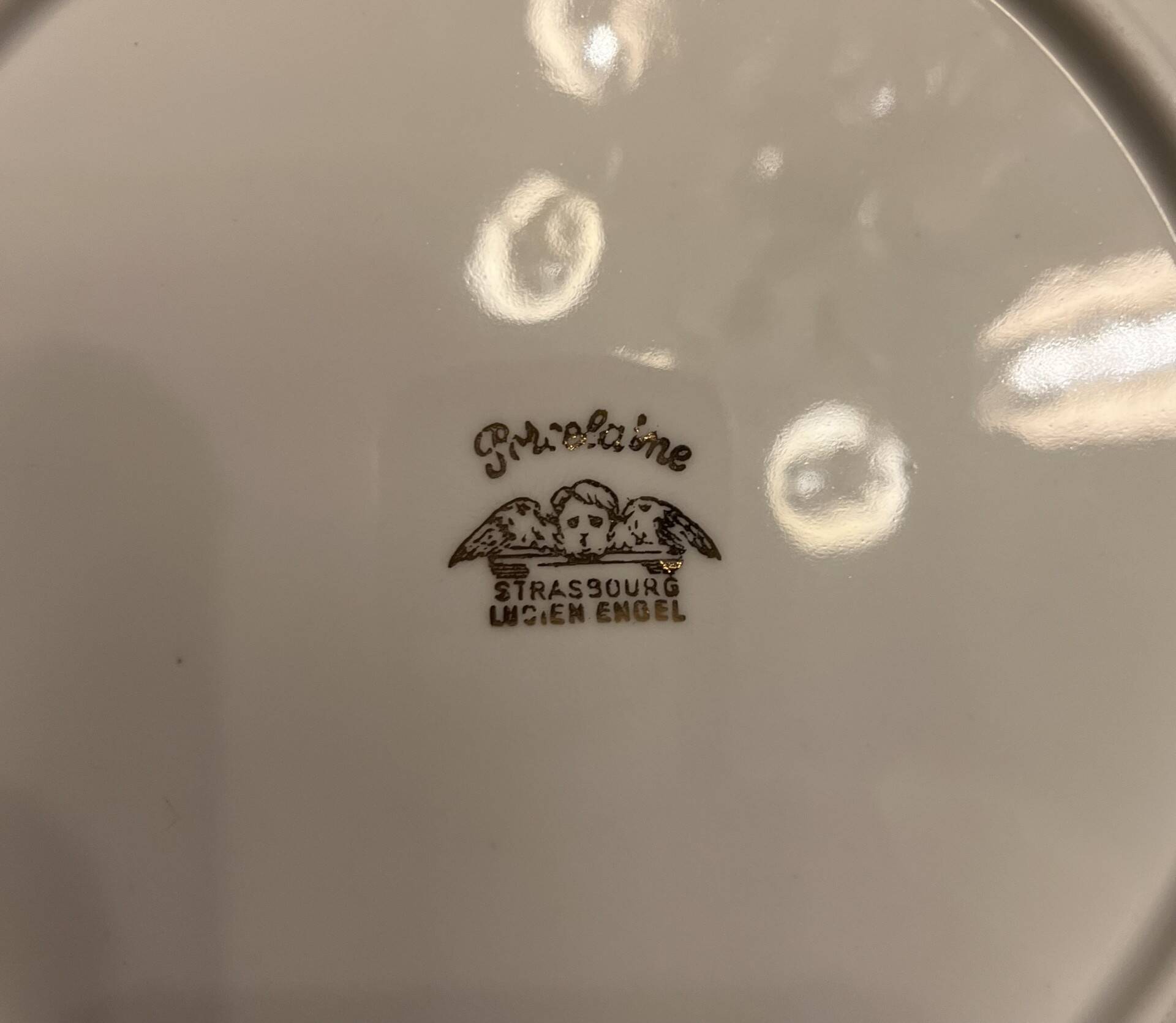 24 plates and a vintage porcelain dish decorated by Lucien Engel.