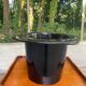 A black top hat-shaped vale turned upside down from the 1960s.