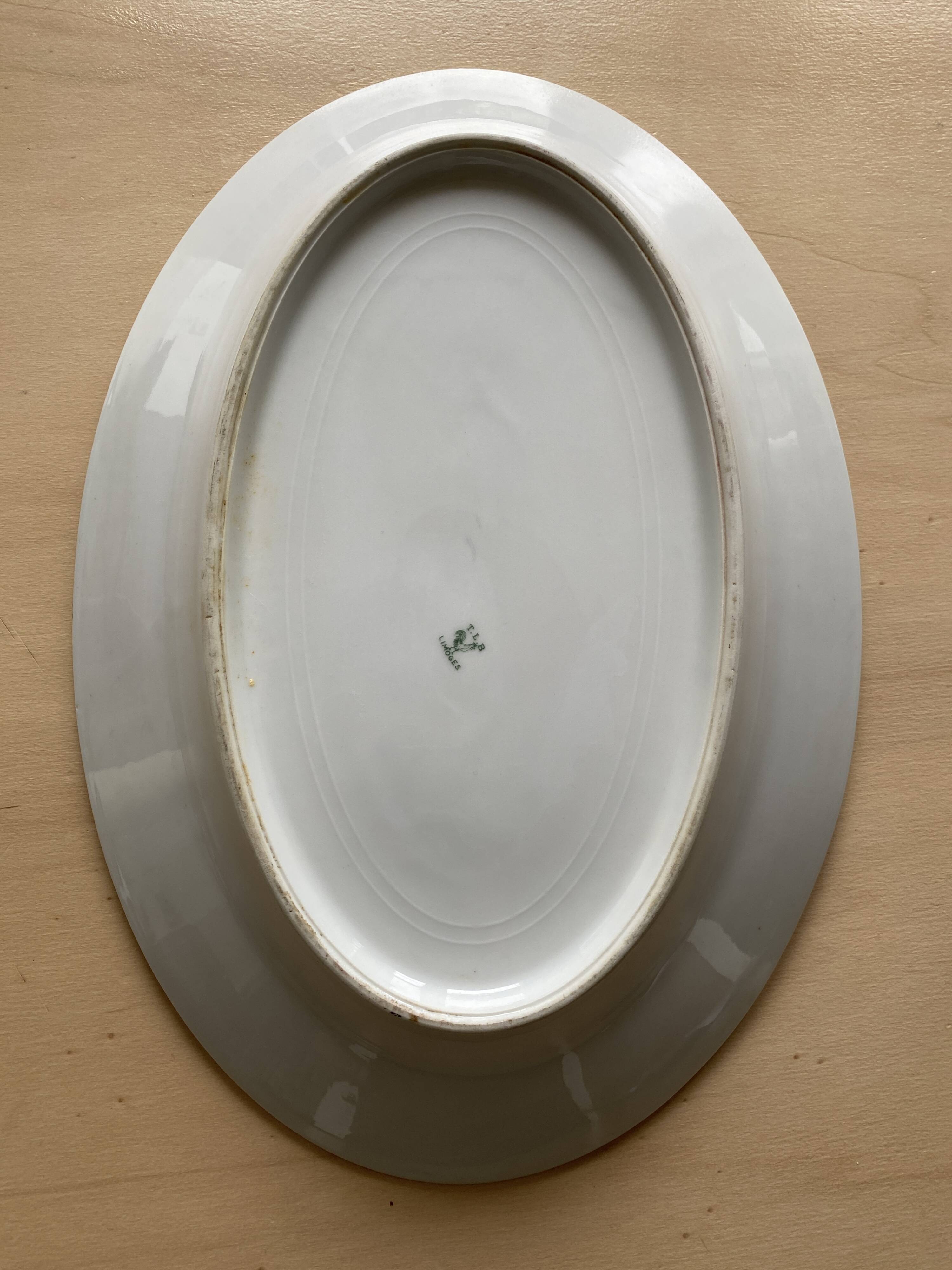 Oval vintage plate in white Limoges porcelain signed T.L.B flowers.
