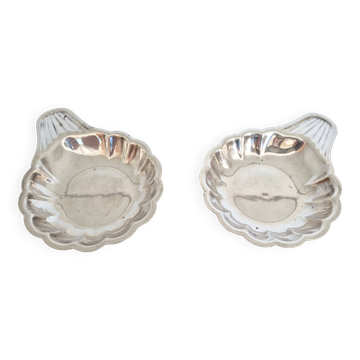Silver-plated shell-shaped butter dishes, in the shape of a scallop shell.