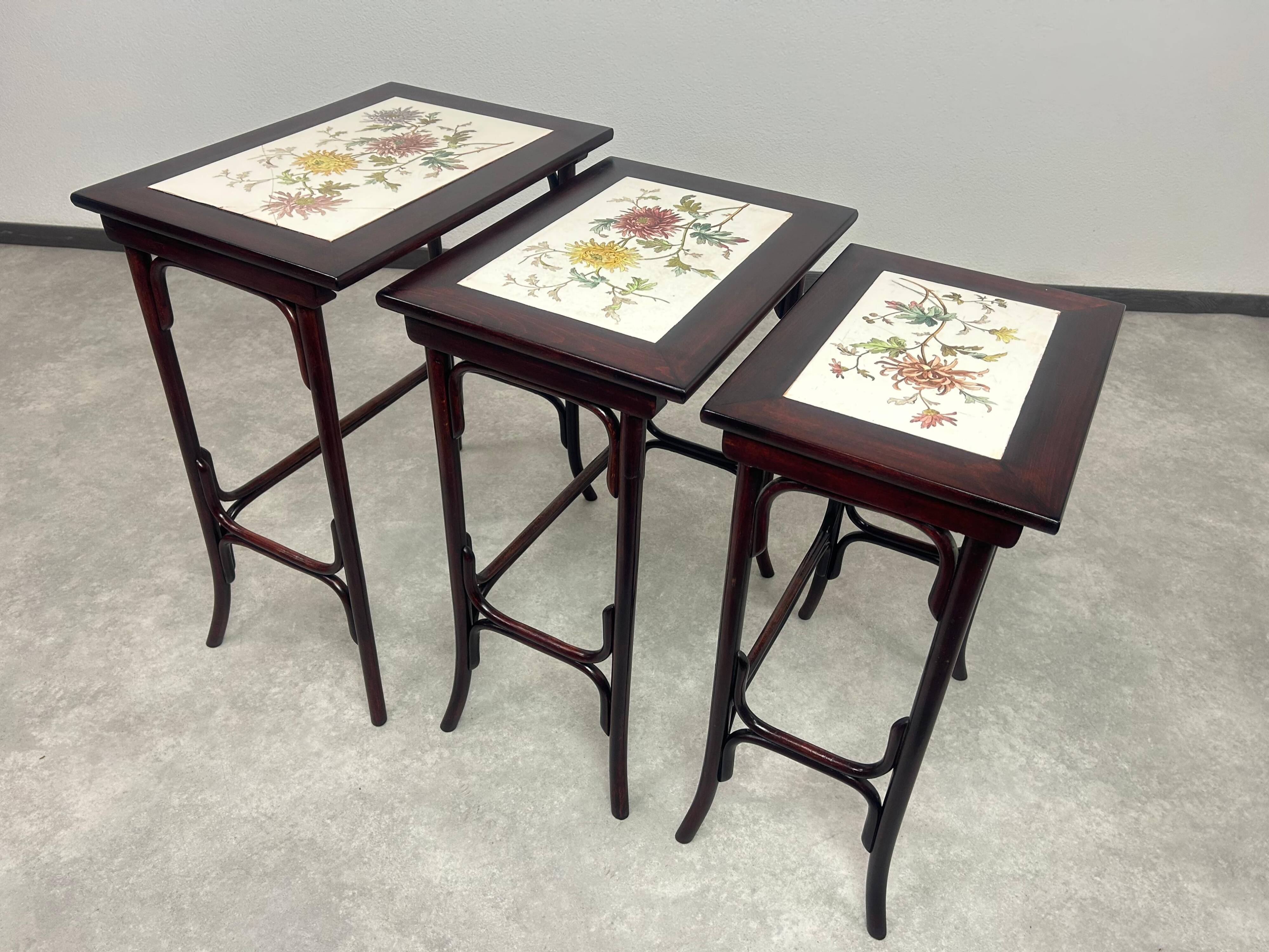 Nested tables in curved wood with ceramic top by Thonet.