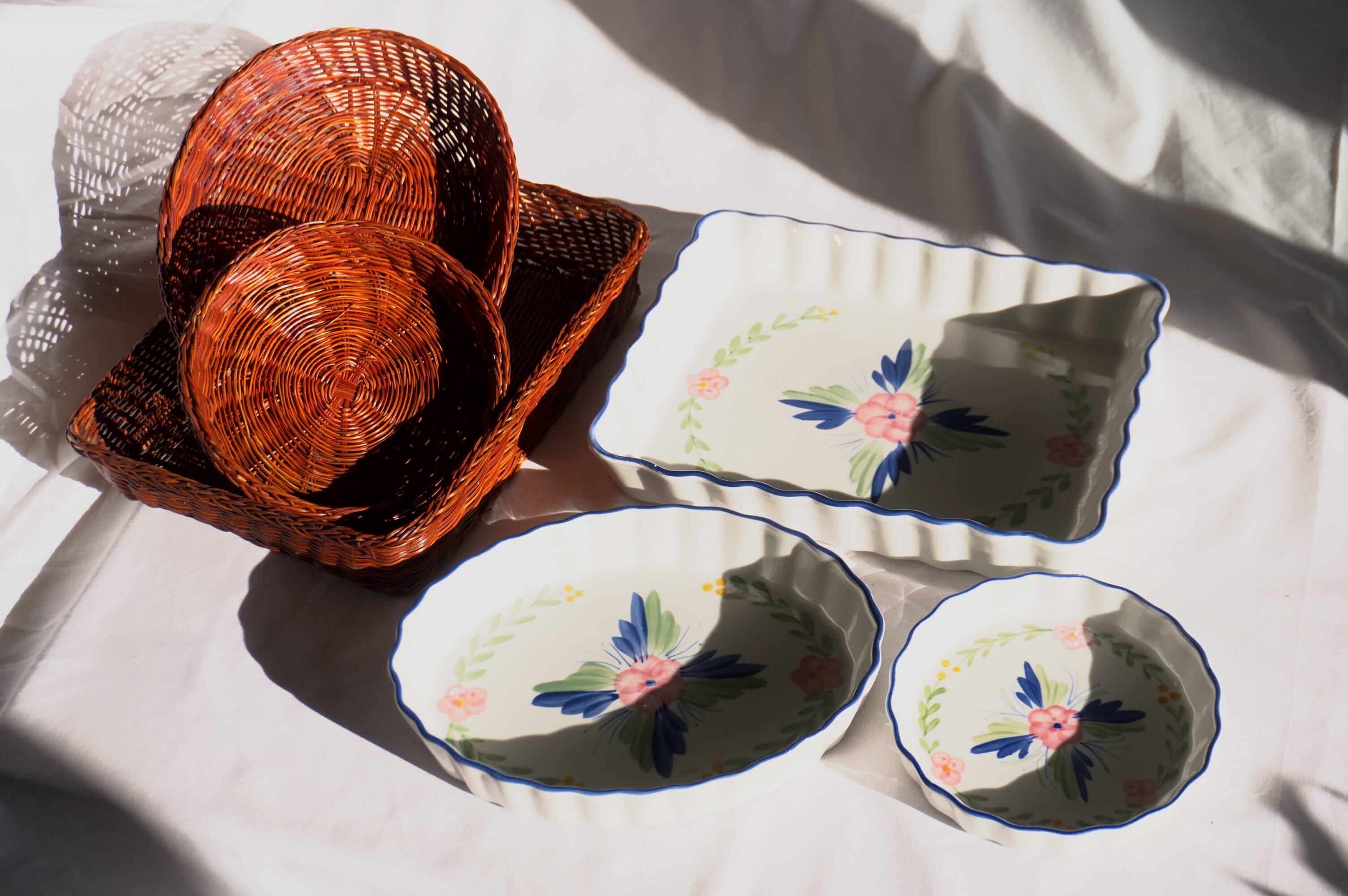 Set of 3 porcelain dishes with floral decorations, with wicker supports.
