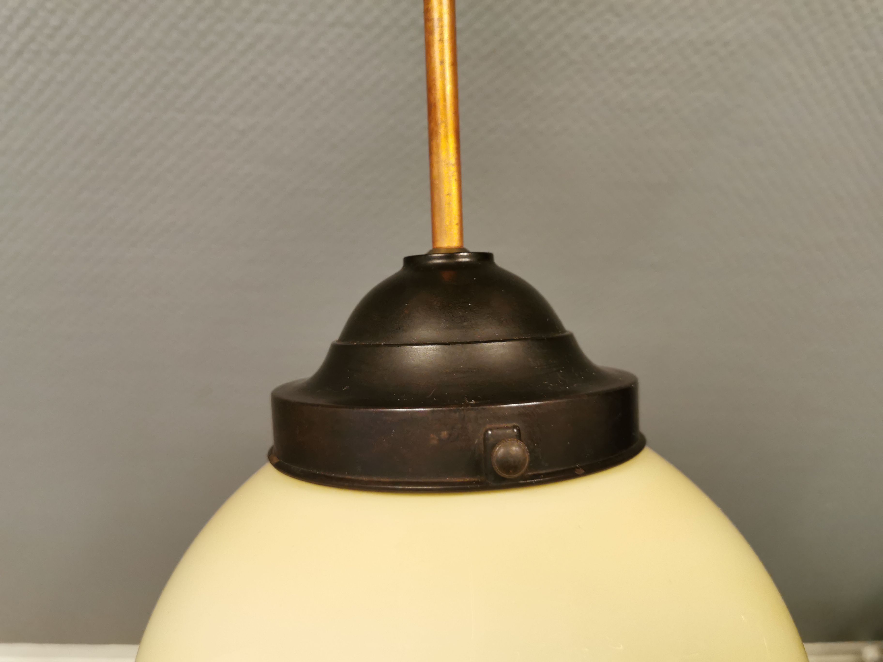 Small Art Deco hanging lamp in cream coloured glass and bakelite top.