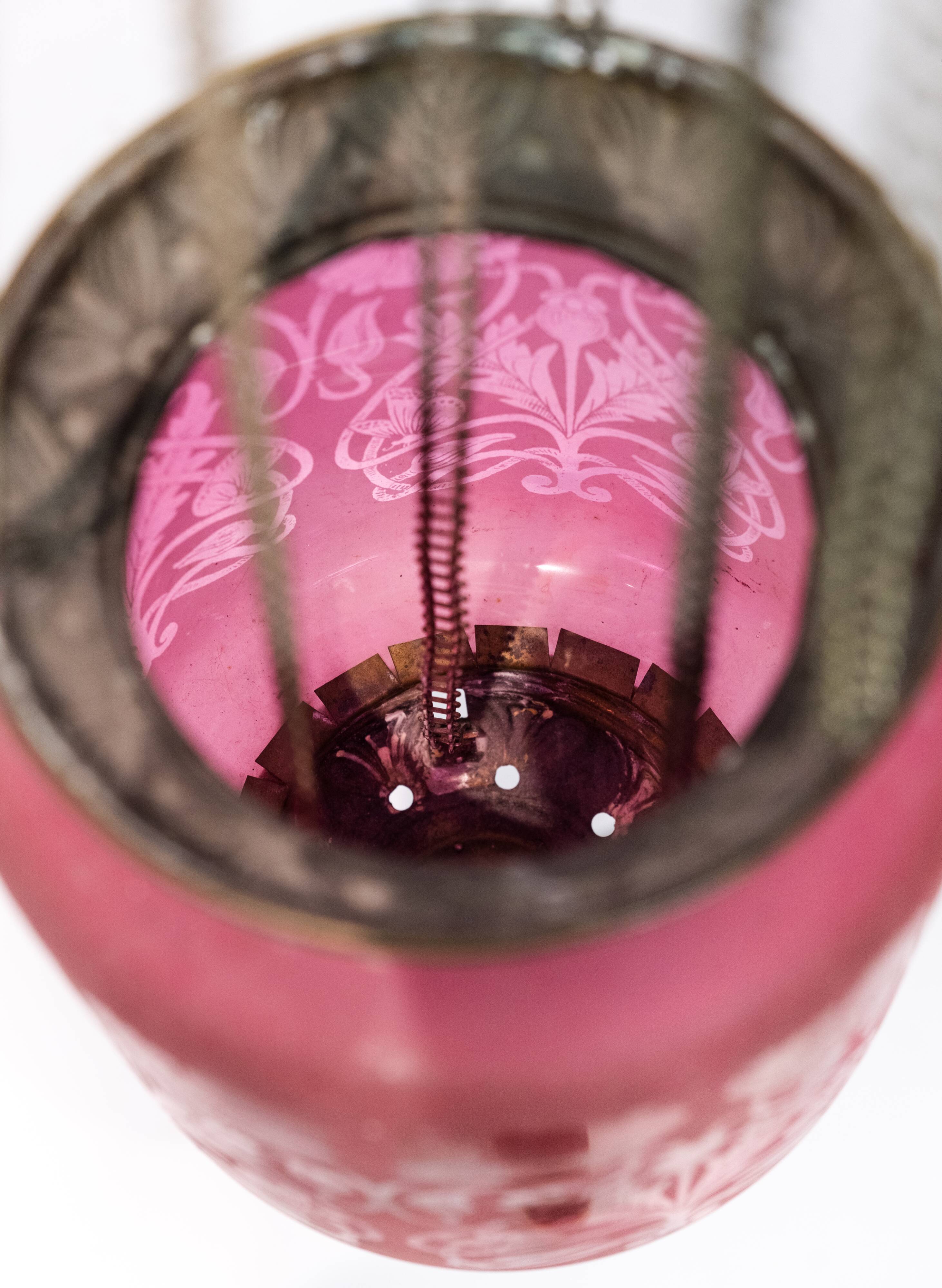 Antique pendant of pink opaline glass with brass edge and suspension from around 1860