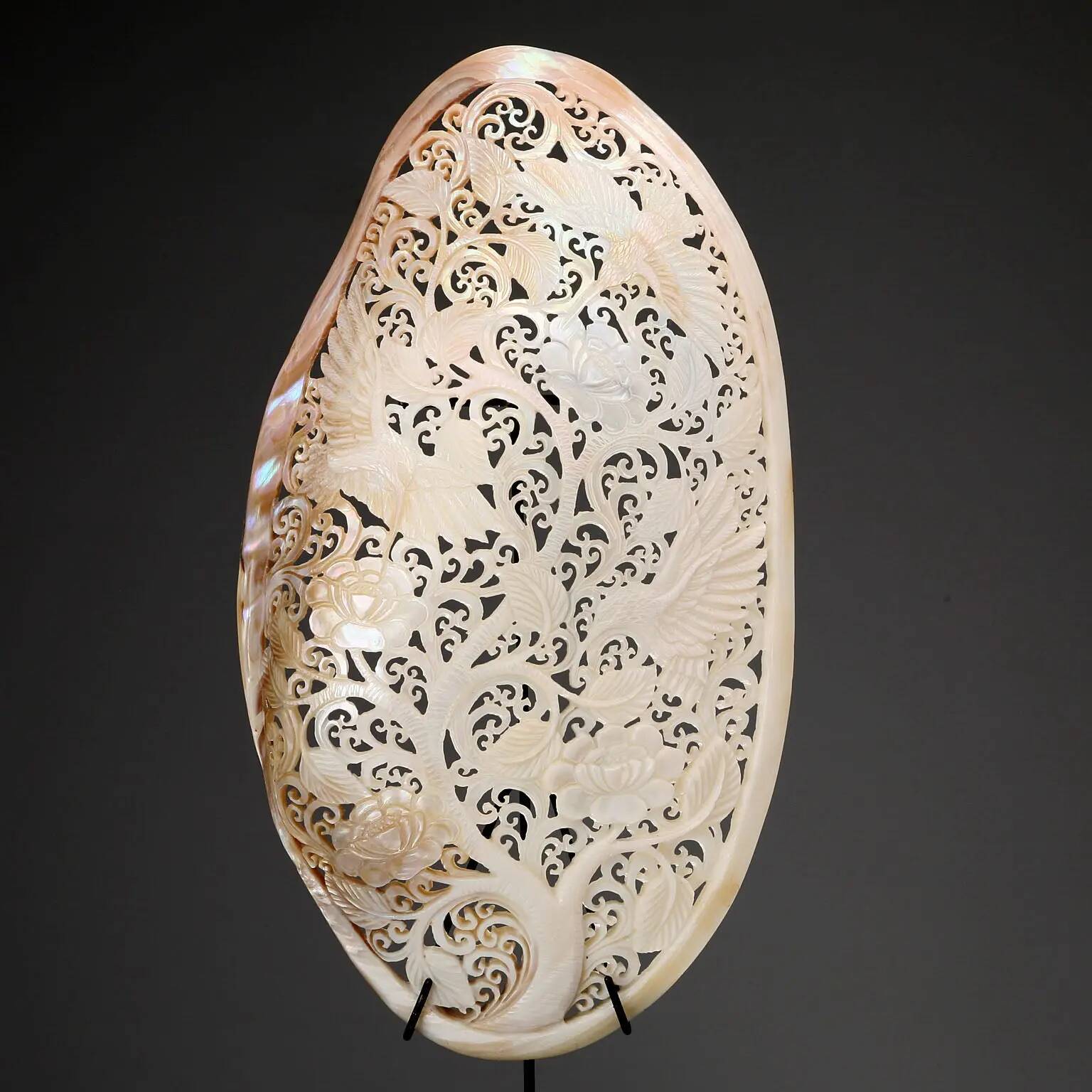 Perforated shell hand-decorated on a wooden base
